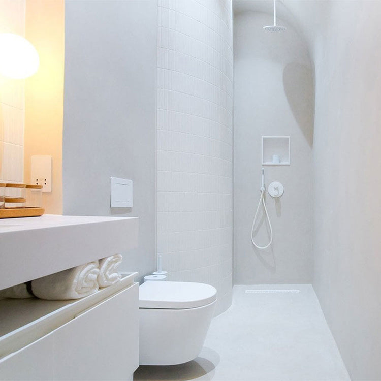 Modern bathroom with white toilet, sink, and shower area.