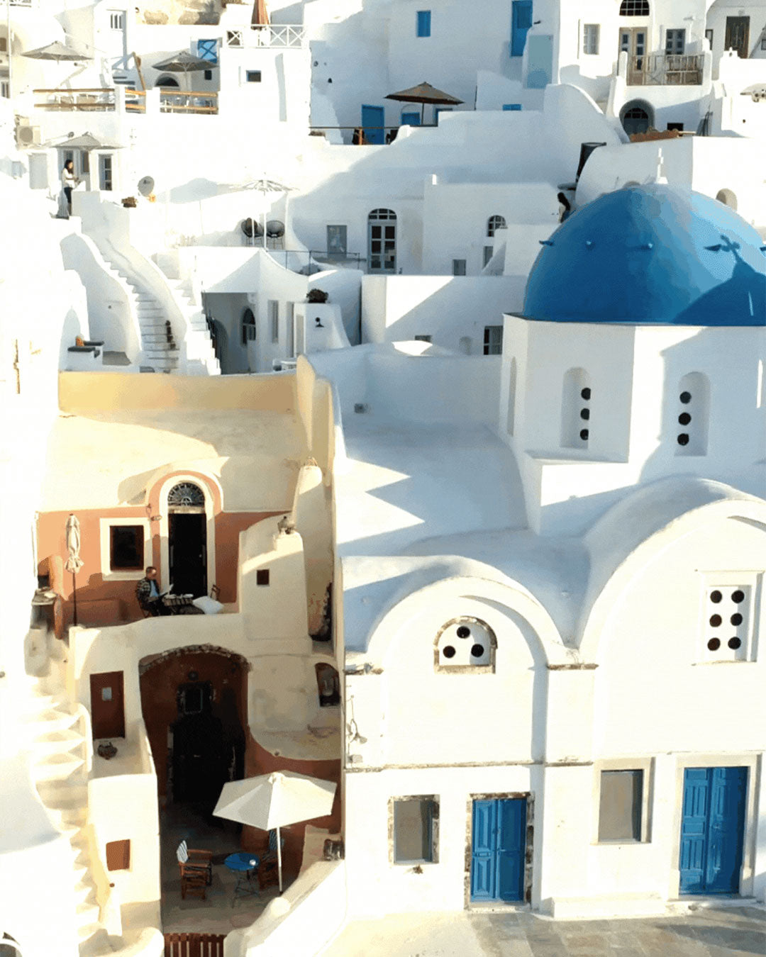 Collage of white buildings with blue accents in a Mediterranean town.