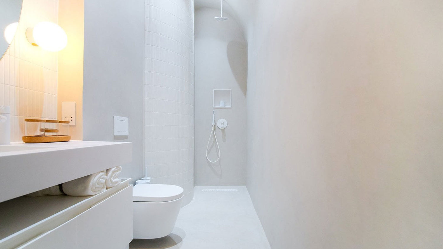 Modern bathroom with white toilet and sink against a light gray wall.