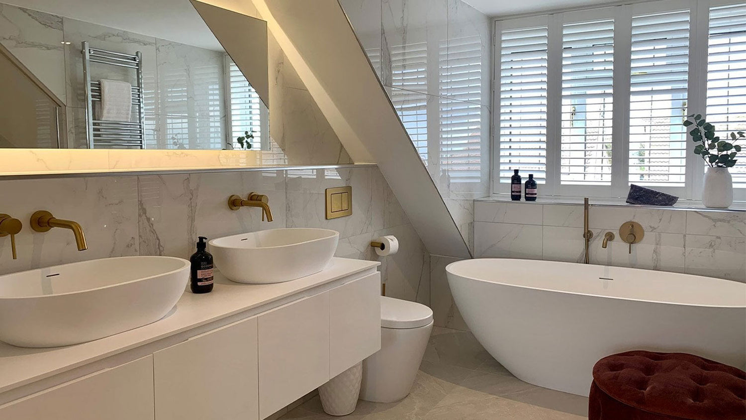 Modern bathroom with freestanding bathtub, sink, and toilet.