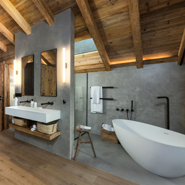 Modern bathroom with wooden ceiling, white freestanding bathtub, and vanity area.