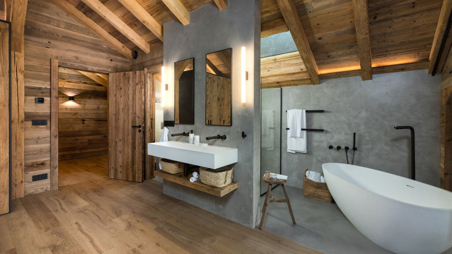 Modern bathroom with wooden ceiling and floor, white freestanding bathtub, and vanity area.