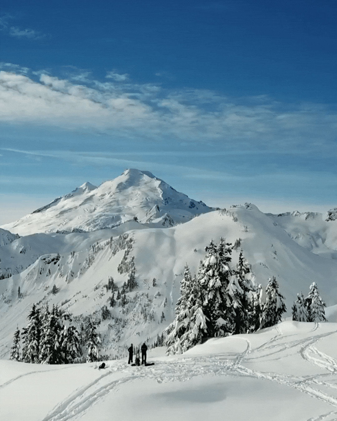 Snowy mountain landscape with skiers on a clear day