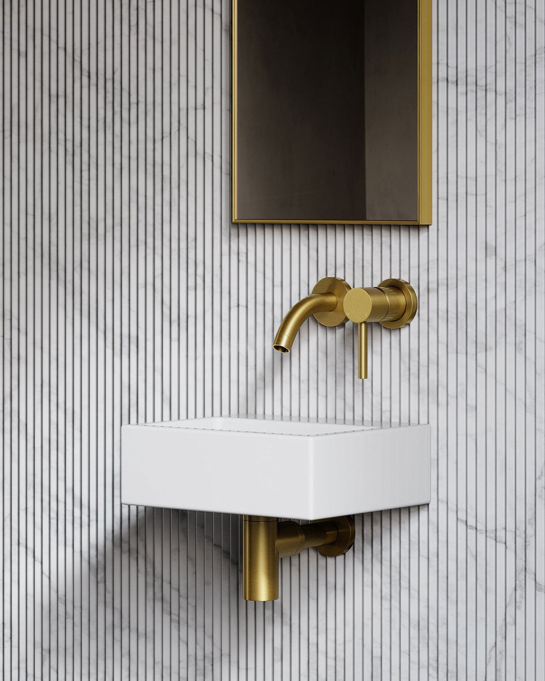 Bathroom sink with gold faucet against a tiled wall