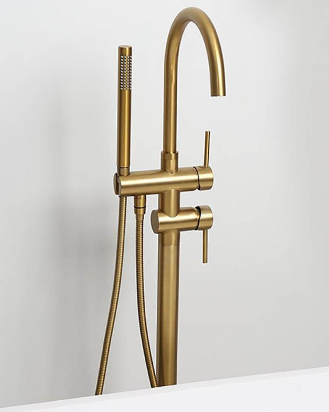 Brass faucet with handheld shower head on a white background