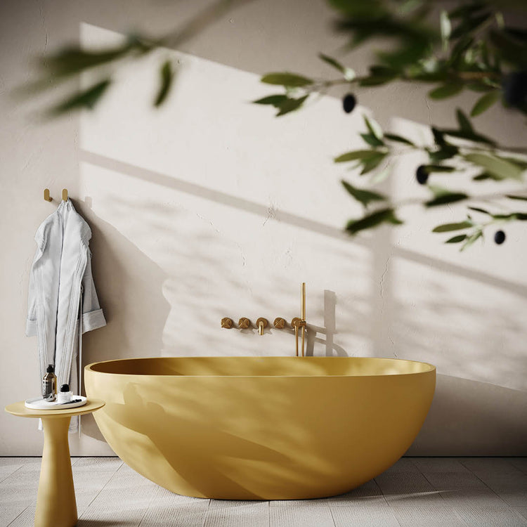 Yellow bathtub in a bathroom with gold fixtures and natural light.