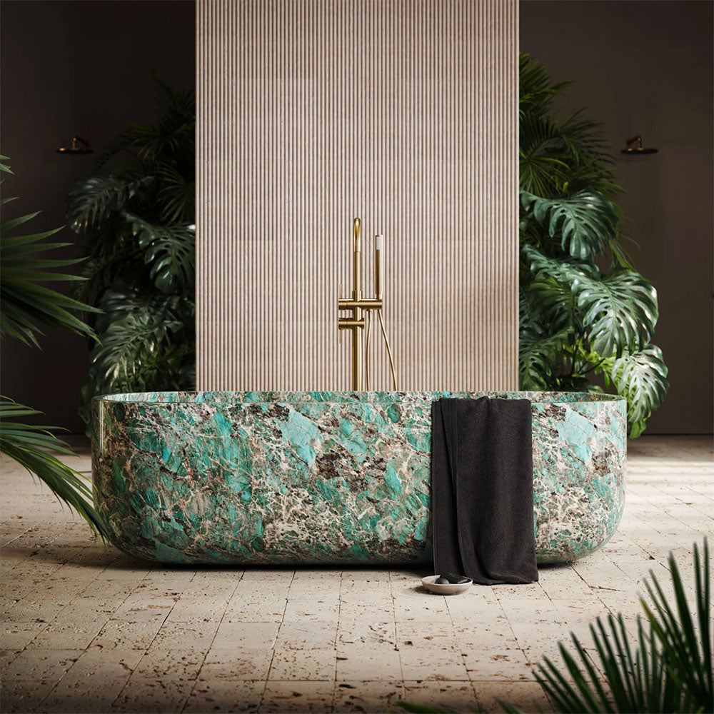 Marble-patterned freestanding bathtub in a stylish room with plants and candles.