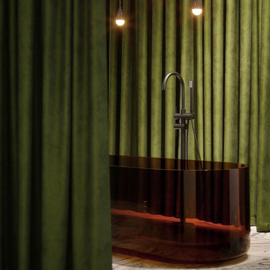 Modern freestanding bathtub with faucet against a green curtain backdrop