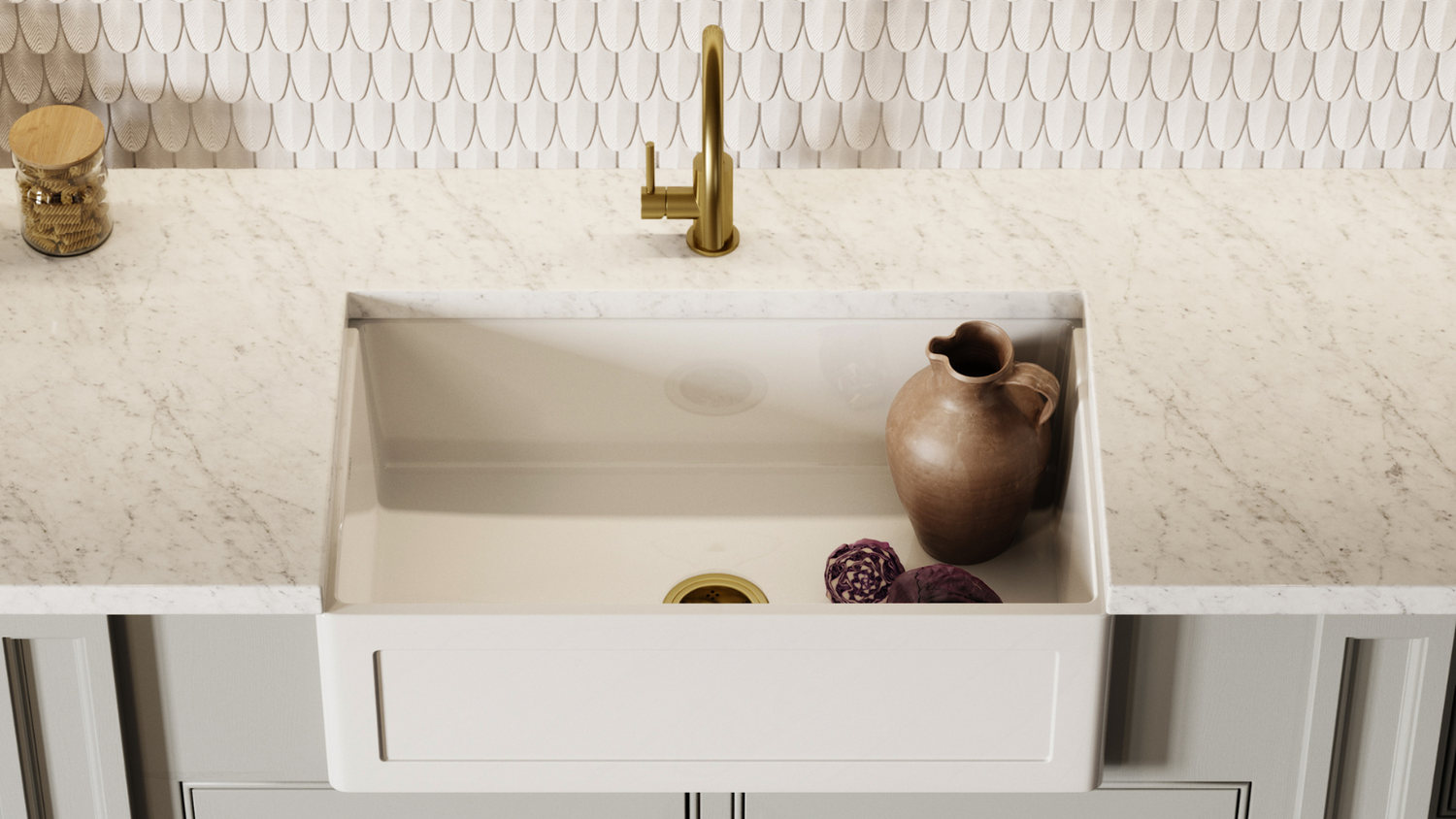Modern kitchen sink with gold faucet and decorative elements on a light-colored countertop.