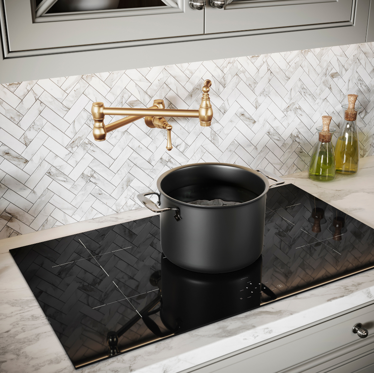 Black pot on a stovetop with a gold faucet in a kitchen setting