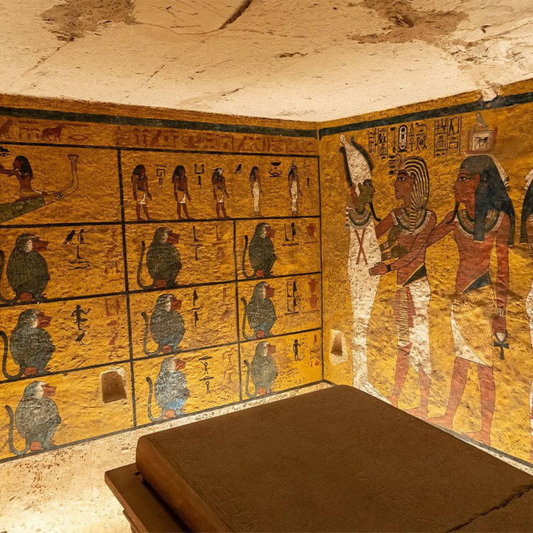 Decorative wall with Egyptian hieroglyphs and figures in a tomb-like setting.