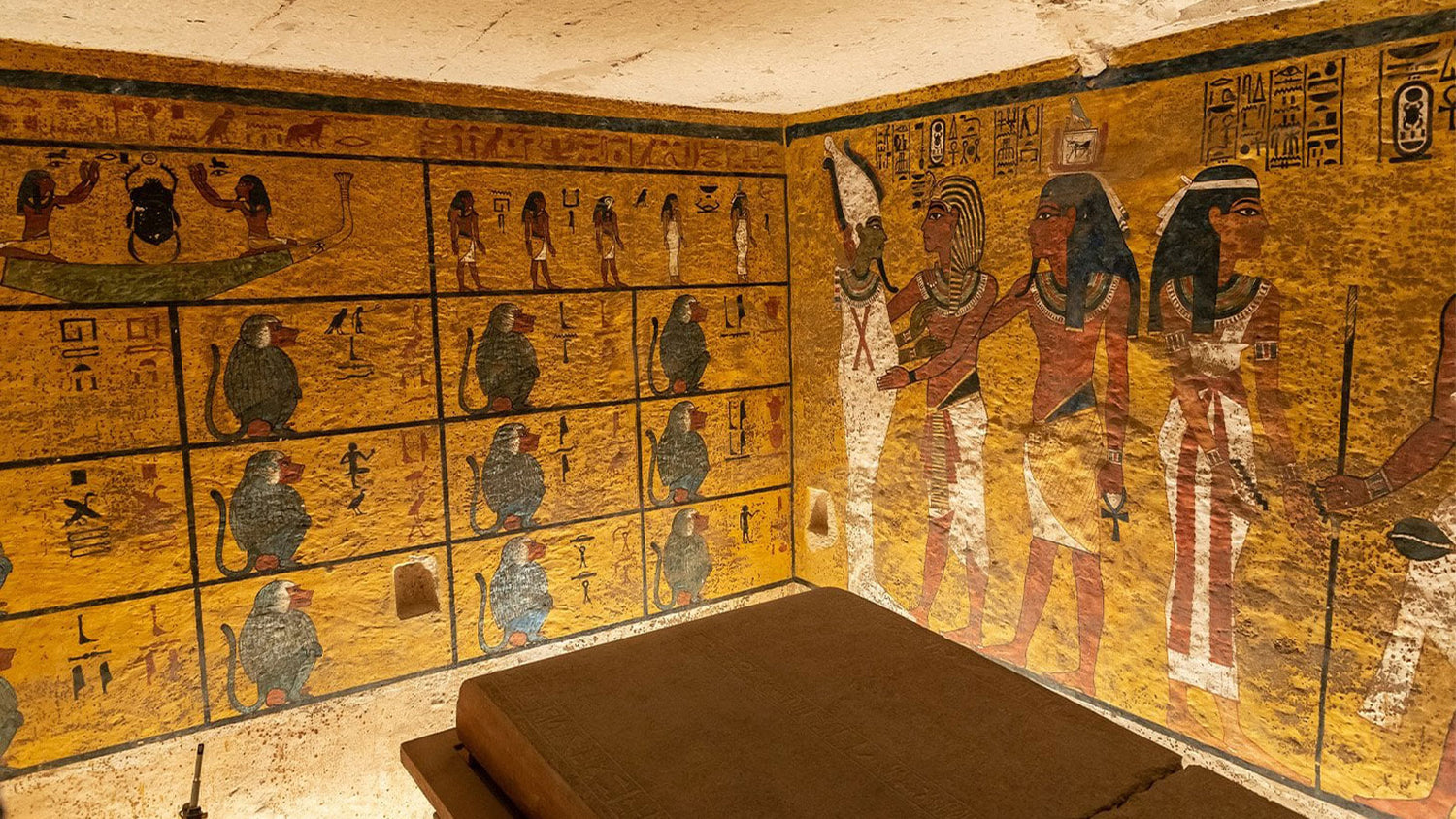 Decorative wall with Egyptian hieroglyphics and figures in a museum setting
