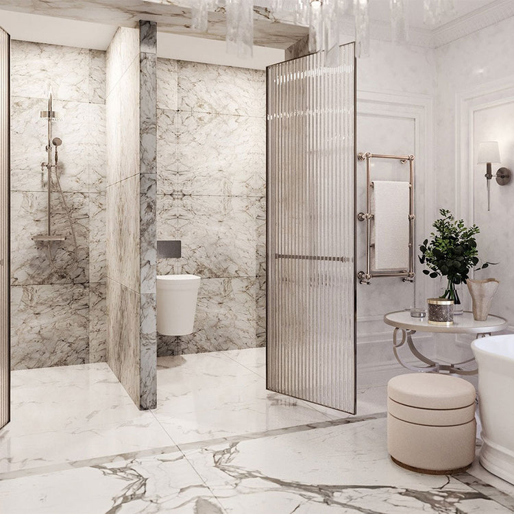 Modern bathroom with marble walls and floor, glass shower enclosure, and white fixtures.