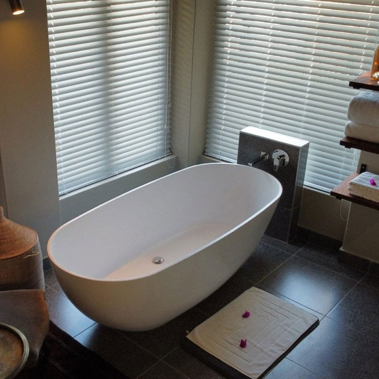 Modern bathroom with a freestanding bathtub and tiled floor.