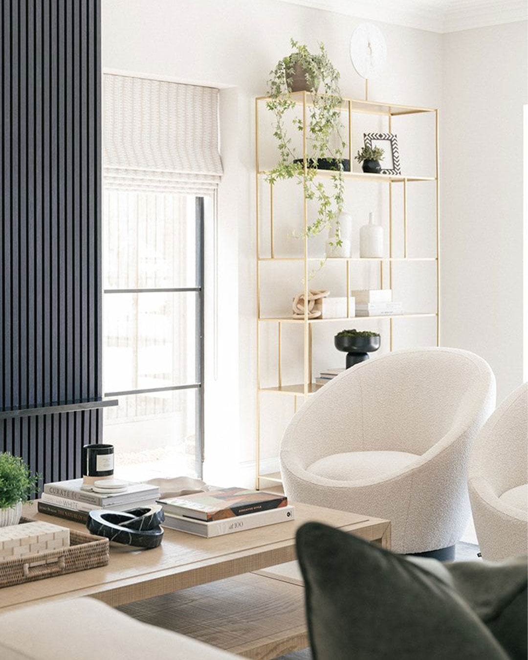 Modern living room with white chairs, a coffee table, and decorative items.