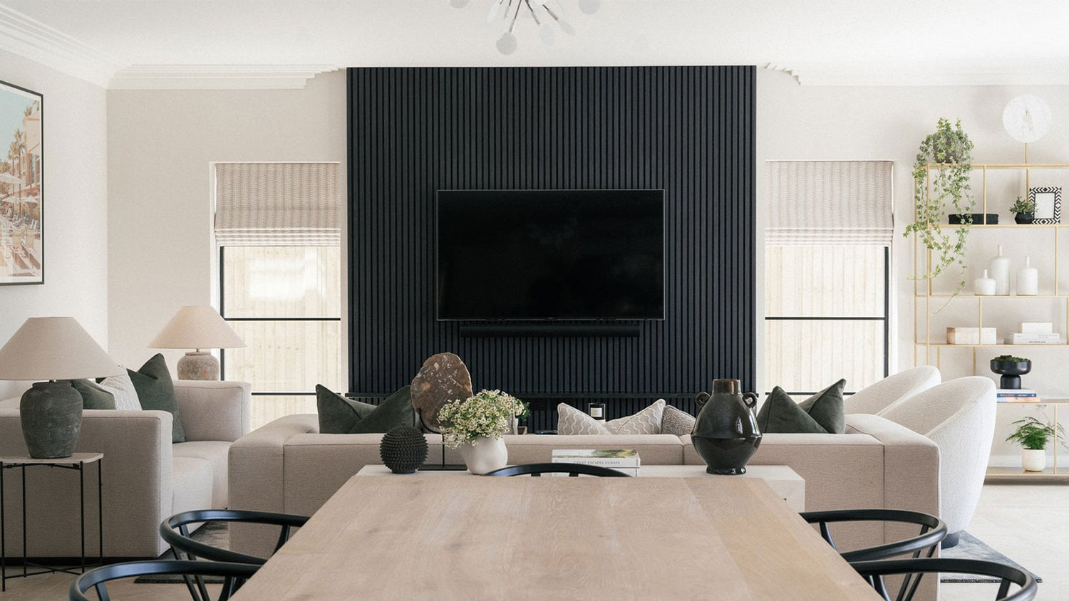 Modern living room with a television mounted on a black paneled wall.