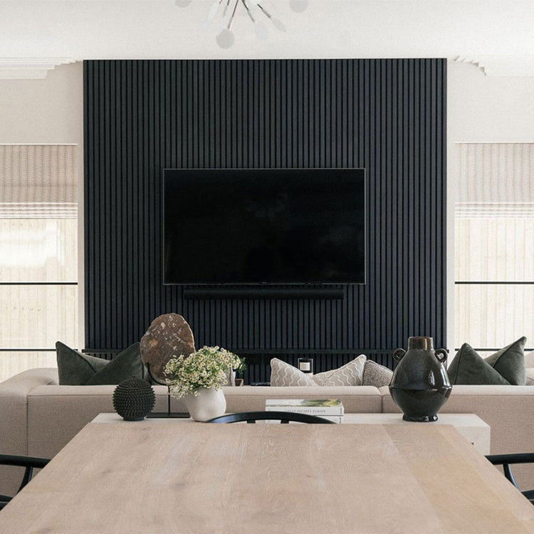 Modern living room with a television mounted on a black paneled wall.