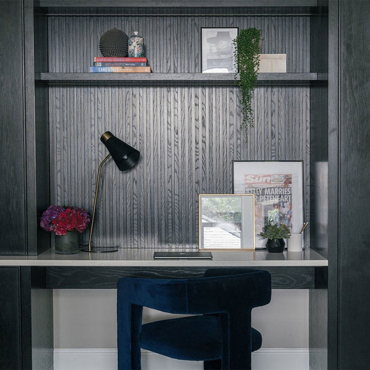 Modern home office with dark wood shelves, desk, and chair.