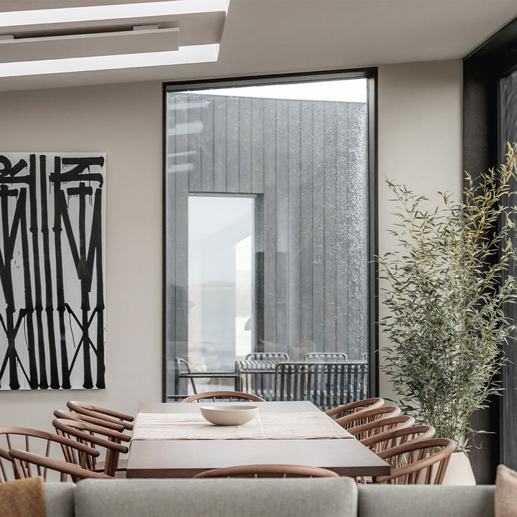 Modern dining room with a table, chairs, and a large window.