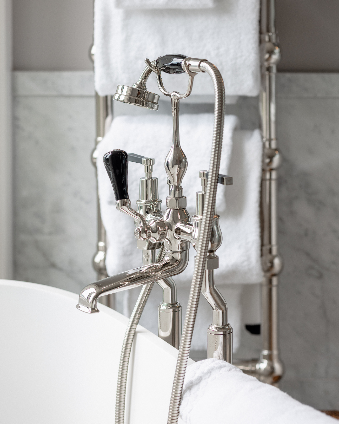 Chrome faucet with flexible hose in a bathroom setting