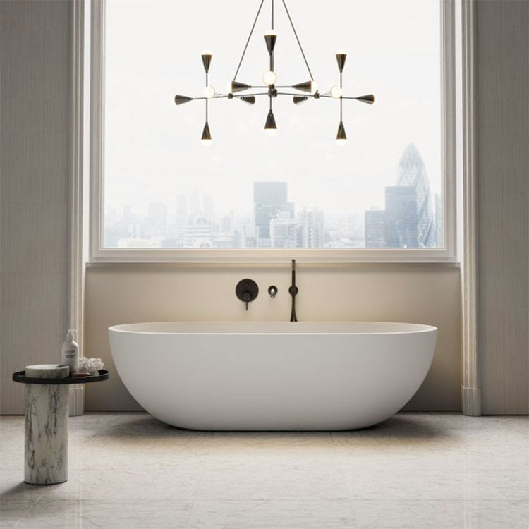 Modern bathroom with a freestanding bathtub, stylish chandelier, and cityscape view.