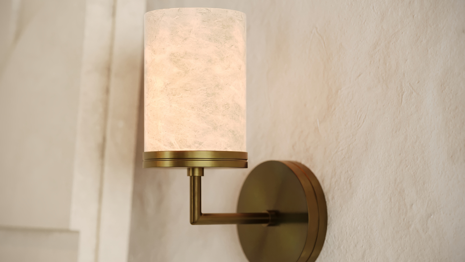 Wall-mounted lamp with a white shade and gold fixture on a neutral wall.