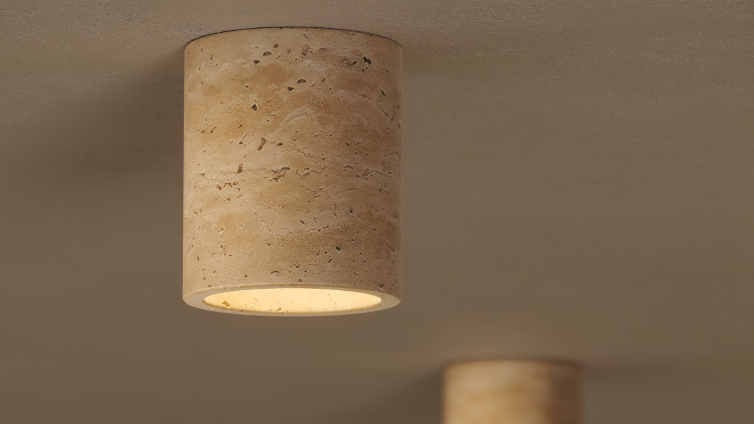 Cylindrical ceiling light fixture on a beige wall