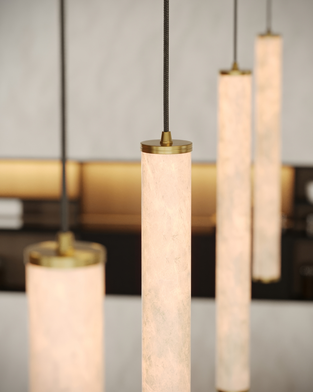 Close-up of pendant lights with marble-like cylindrical shades in a blurred indoor setting.