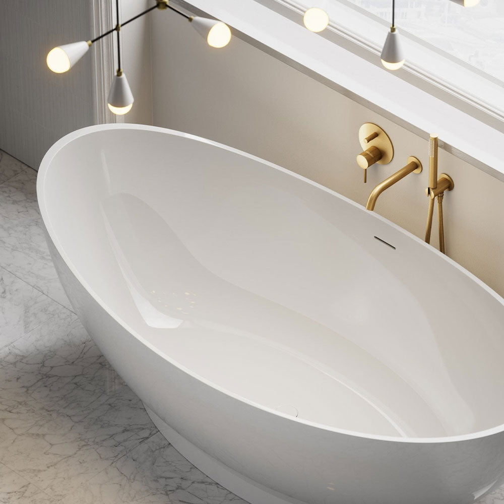 Modern freestanding bathtub with gold fixtures in a bathroom setting