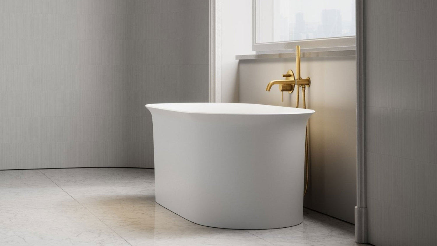 White freestanding bathtub in a modern bathroom with gold faucet