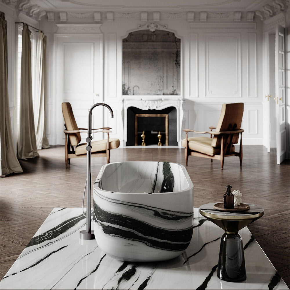 Marble-patterned freestanding bathtub in a luxurious room with wooden floors and a fireplace.