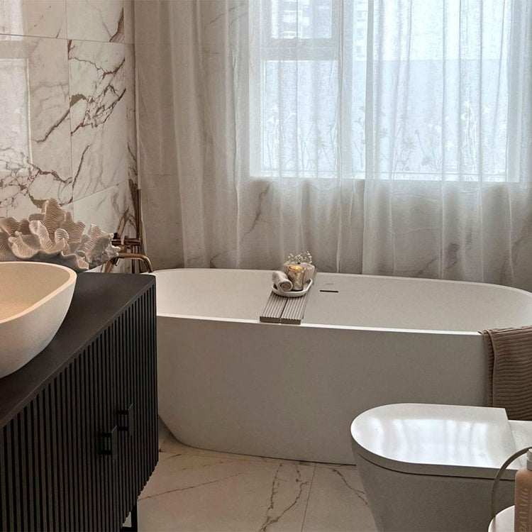 Modern bathroom with a bathtub, sink, and decorative elements.