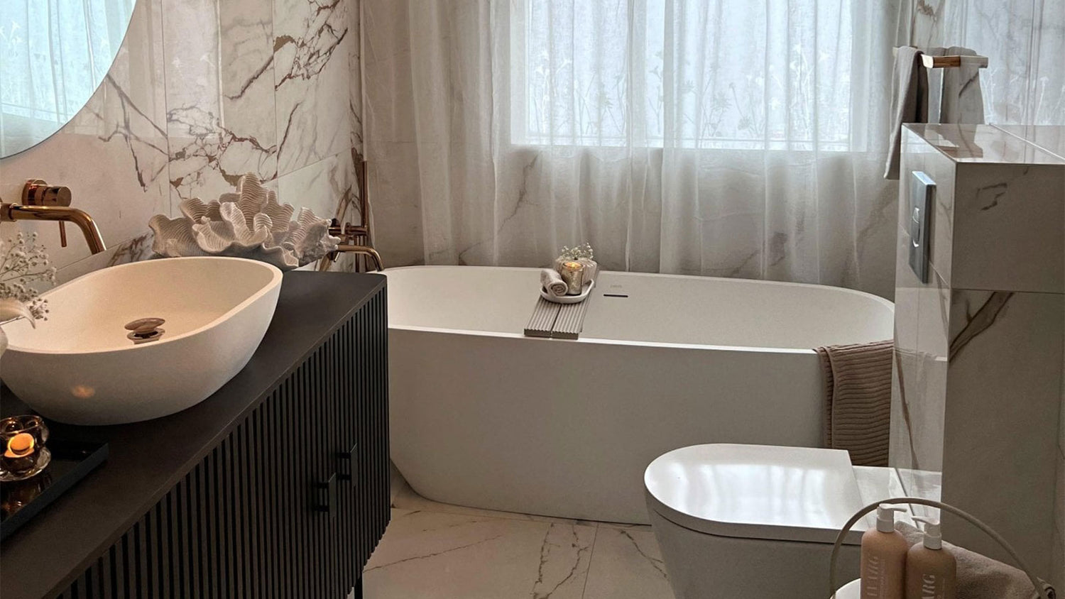 Modern bathroom with a bathtub, sink, and decorative elements.