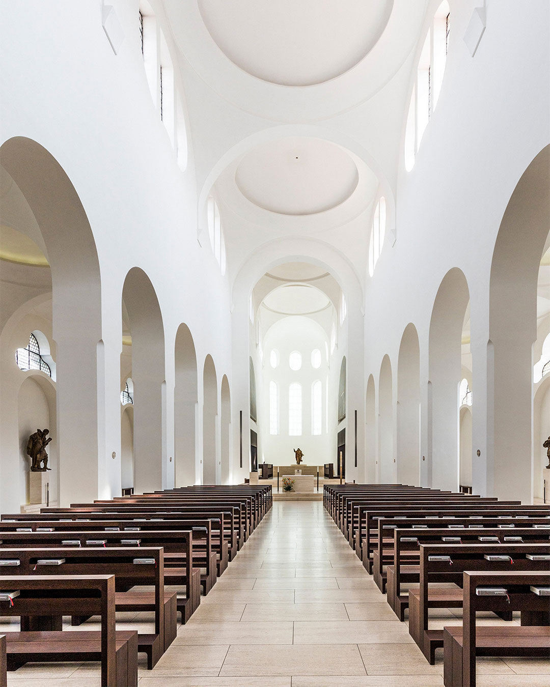 Large, open church interior with rows of wooden pews and high ceilings.