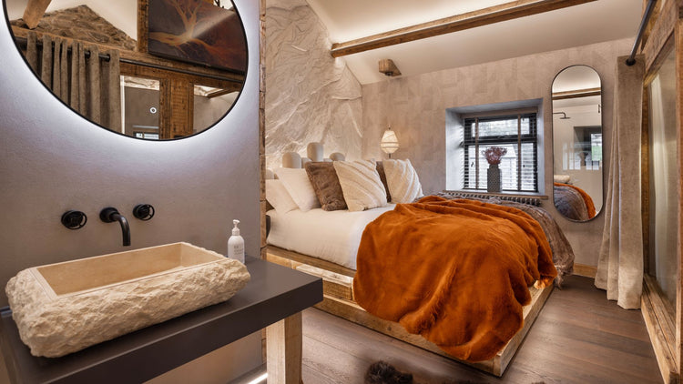 Modern bedroom with a bed, vanity, and large mirror.