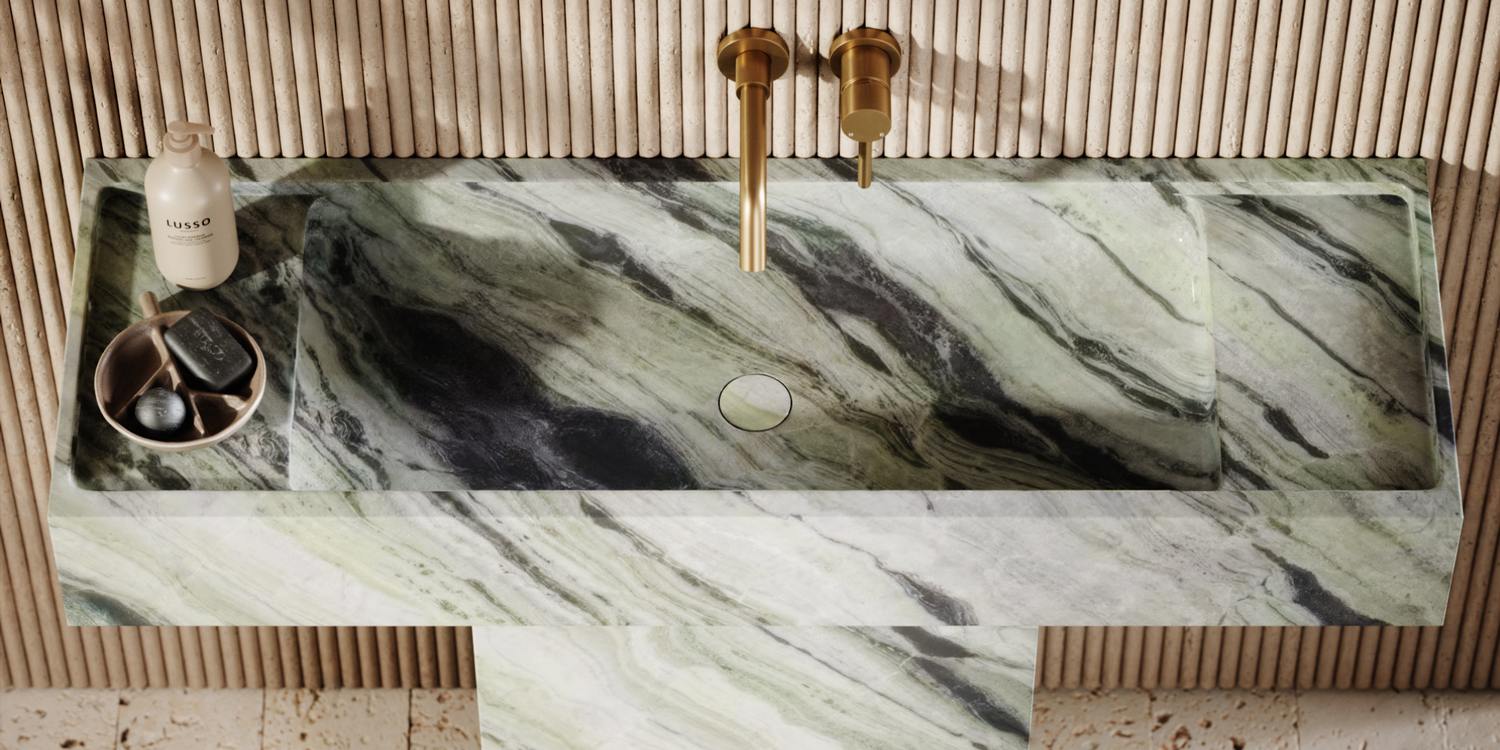 Marble-patterned sink with gold taps on a neutral background