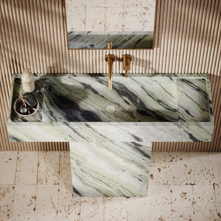Marble-patterned sink with gold fixtures in a bathroom setting